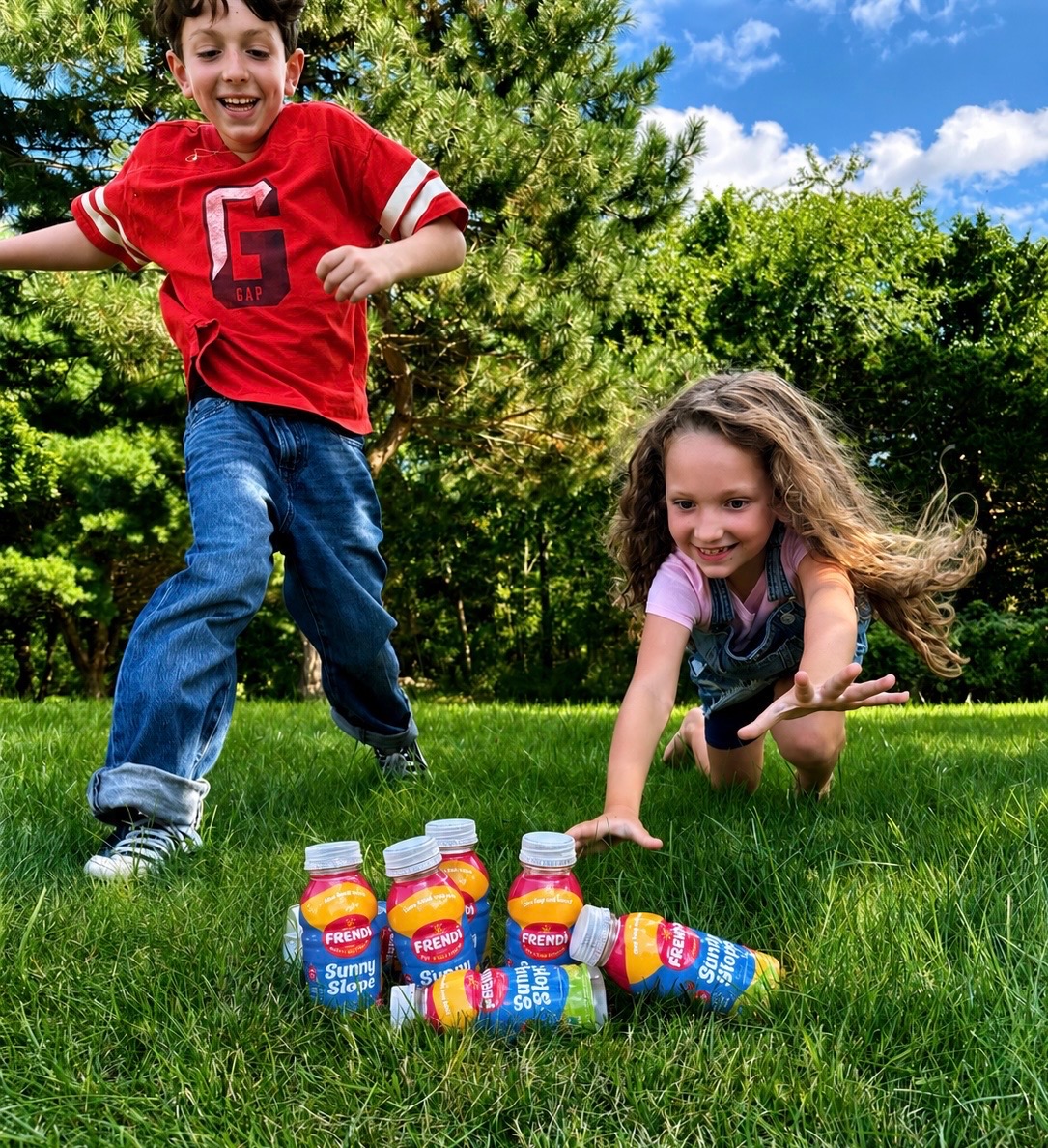 Kids playing in the grass with Frendi bottles